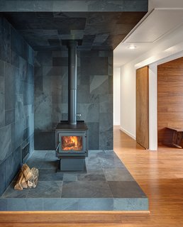 Vermont slate covers the area around the True North wood stove. Wide-plank Yanachi Carbonized Strand Woven Bamboo covers the floors.