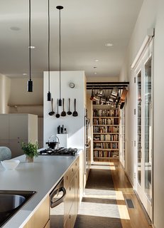 Orrill, a culinary professional, used Ikea’s kitchen planning software to plot out cabinetry and appliance placement. Levy split the 30-foot-long space into a private back kitchen, with an oven and staging area, and a public cooking station with a white laminate countertop—a maneuver that means guests in the adjacent dining area never see the messy stuff.