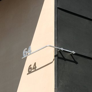 The play of shadows on the iconic shape, as well as on the shapes of the house numbers, is a Levy trademark.