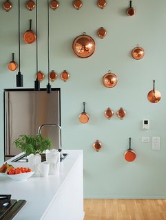 Orrill wanted the kitchen to be the central hub for entertaining, so everything is kept inside minimalist cabinetry—except for the copper pots and pans hanging on the back wall.