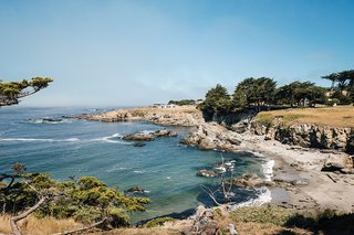 Affordable Beach Home Dream - Photo 1 of 3 - The view from Gabriel Ramirez’s property in Sea Ranch, California, where meadow grasses and cypress trees give way to craggy cliffs and the lapping Pacific Ocean. His house joins those that a cohort of forward-thinking architects built along this stretch of coast in the 1960s.