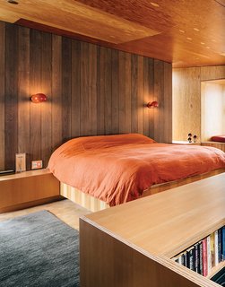 Boi sconces, which David Weeks designed for Ralph Pucci, illuminate the bedroom. The area rug is by Stephanie Odegard.