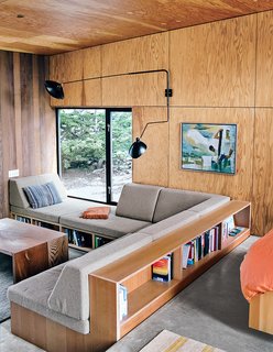 The guesthouse has similar built-ins and is outfitted with a reproduction rotating sconce by Serge Mouille and rugs by Stephanie Odegard.