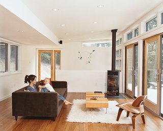 Take Me Home - Photo 2 of 7 - A Movie sofa, by CB2, and a Rais wood-burning stove are in the living room.