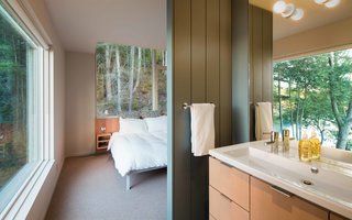 A Design Within Reach bed is steps away from a Second Floor sink by Duravit that’s outfitted with an Essence Grohe faucet. Benjamin Moore’s Templeton Gray is painted on the master bathroom’s wood paneling.