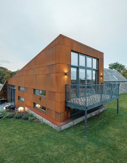 McAvoy rebuilt the farmhouse’s original stone walls piece by piece. The couple found the sofa and ottoman at a local shop, Annie Mo’s. For the new structure, Grace & Webb fabricated a laser-cut steel balcony.