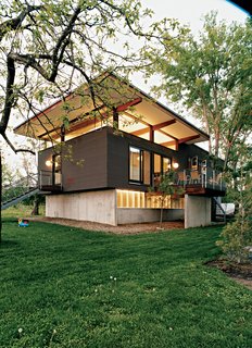 The house in the evening, with the main living space and basement illuminated. "It gets pretty windy here," Jamie says. "I have nightmares about the roof coming off like the lid of a can."