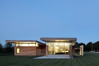 12 Striking Examples of Clerestory Windows in Modern Homes - Photo 11 of 12 - A system of clerestory windows, positioned underneath a cantilevered roof, strategically filters natural light through the interior. A full-height window in the living area provides dramatic views of passing storms.