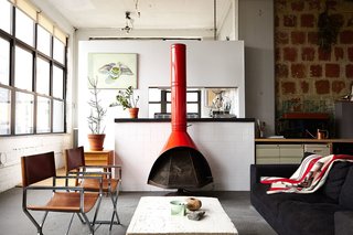 "I’m not trying to hide anything. I wanted to stay true to the industrial look," explains Owen Wright, the owner of this Brooklyn loft. Owen works with his building’s landlord and consequently has accrued countless pieces of furniture from both former tenants and Craigslist—including this 1960’s bright orange metal fireplace and pair of steel frame chairs Owen had reupholstered. A BoConcept sofa and coffee table Owen constructed himself complete the living room.