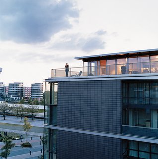 Cox enjoys the view from his penthouse terrace. The steel used for the terrace, and the brick-colored cladding of the building, echo the industrial architecture of the area. The angles suggest a ship, a nautical link with Duisburg’s past as a major port.
