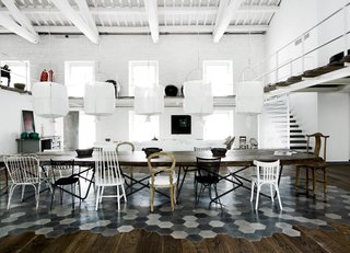 Visitors pass by a sentry wall of lamps from Design House Stockholm on their way to the airy living-dining room with its 52 windows.