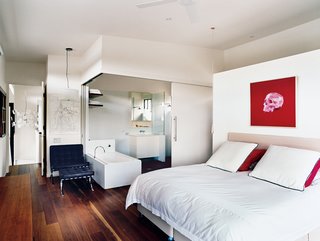 The serene all-white bathroom can be sealed off from the master bedroom by two sliding doors, or left open for a loftlike feel.