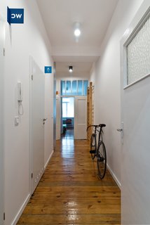 The subdued white and grey interiors help highlight details such as the flat's original wood floors. Apart from the blue bathroom identifiers and room markers, the only other colors used are the occassional orange and green, the same hues that are used in several of Wierciński’s other projects.