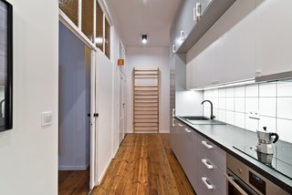 Working within the constraints of a modest budget, the design team creatively mixed custom-designed pieces with more affordable items. For example, the shared kitchen features a Franke kitchen sink and IKEA cabinetry and appliances. Framing the kitchen wall, an old gymnasium ladder adds an historical touch. The biggest challenge of the project, says Wierciński, was to "execute a low budget project with a unique original style."