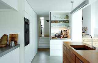 When their house was in need of a pick-me-up, a London couple turned to the designer of their favorite coffee shop for an industrial-strength renovation. A Lebanese cedar island and stainless-steel countertops provide ample work space—and a place to display treasured items, such as the Buono V60 drip kettle by Hario. The island features a Franke sink with a Vola faucet. The oven is by Siemens and white MDF cabinets stow tools.