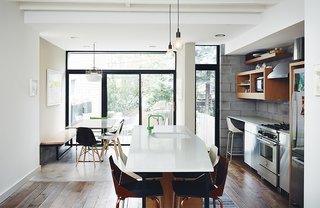 Brooklyn Home Keeps its Historic Bones While Getting a Much Needed Interior Update - Photo 6 of 13 - In the kitchen, matte Caesarstone tops an island composed of custom millwork and stainless-steel Ikea cabinetry. A bright-green Vola faucet adds an idiosyncratic touch of color.