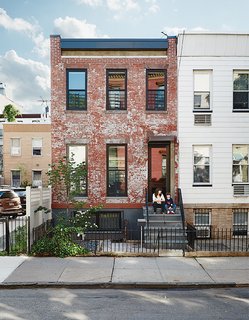 Brooklyn Home Keeps its Historic Bones While Getting a Much Needed Interior Update - Photo 1 of 13 - Margarita McGrath and Scott Oliver of Noroof Architects termed the 1,650-square-foot house in Greenpoint, Brooklyn, "Pushmi-Pullyu," in reference to the interior-exterior flow they created. Resident Jill Magid, pictured on her front steps with son Linus, is a conceptual artist; she fabricated the neon house numbers.
