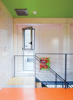 The house has many unexpected splashes of color, and exposed industrial materials are used throughout. The diamond-plate steel shown here was also used as a kitchen backsplash, covered with a coating of pink paint.