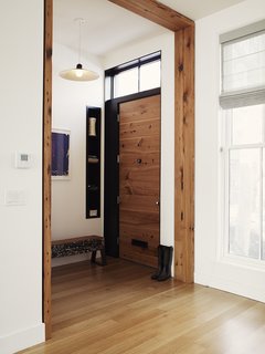 Even a few pieces of salvaged lumber can have a big impact. This entryway in a Brooklyn townhouse, renovated by Bangia Agostinho Architecture, reused hemlock fir joists from the existing building structure as casework around the main entry door. The trim has a simple, modern profile, ensuring that it makes a contemporary statement. In the entryway is another repurposed piece of wood that was charred in a fire more than 100 years ago. It has since been painted and repainted—creating a unique patina and texture—and transformed into a bench.