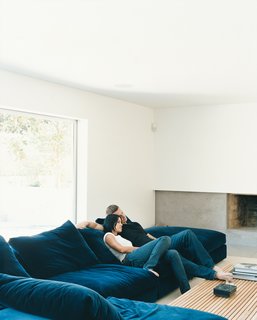 Griffith and LeBlanc cozy up on the Flexform sectional in the den, where one of the home’s two original wood-burning fireplaces has received a new concrete hearth and mantel. The room, which is located a half flight of stairs down from the main living area, feels unusually light and airy because of new, wider sliding doors and and a fresh coat of bright white paint.