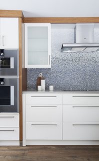 In Ontario, this 19th-century home abuts a river, where the residents enjoy kayaking and swimming in warmer months. This geographic location partially inspired the wave-like backsplash. Each tile was hand-cut and individually placed by artisans from New Ravenna.
