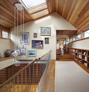 The atrium features a custom stainless steel railing designed by Moser and manufactured by the homeowners’ son-in-law, who owns a local fabrication shop. The self-supporting steel rod system and Sonneman Bubbles Light pendant light nicely contrast with the surrounding woodwork.