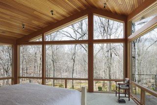 From the northeast corner of the master bedroom, the homeowners can walk out onto a deck area to enjoy the view of the woods.