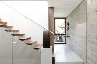 "We didn’t want panel-formed, smooth-like-glass concrete; we wanted texture," Fleetwood says. A cast-resin piece by DeWain Valentine sits at the foot of the sculpted walnut stairs.