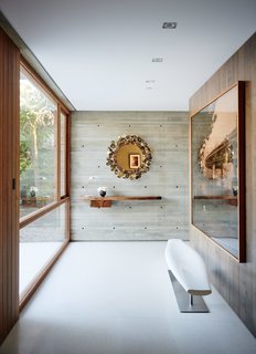 A Taryn Simon photograph in the entry greets visitors. The vintage Raindrops mirror is by Curtis Jere; the Lucellino table lamp is by Ingo Maurer.