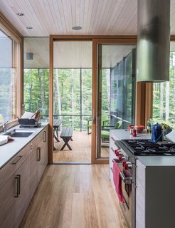 In the kitchen, the cabinetry is walnut veneer with a weathered finish applied by cabinetmaker David Rogers. "The process involved sanding and rubbing in stain as well as adding a clear finish," project architect Eero Puurunen says.