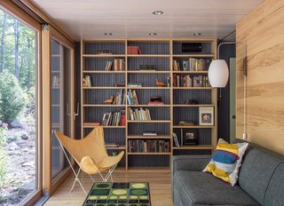 In the library, a Grant sleeper sofa by Mitchell Gold + Bob Williams is paired with a Cigar wall sconce by George Nelson.