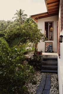 Concrete pavers lead from Azor’s back door to his backyard garden and deck. The roof’s overhang protects the home’s walls from rain.