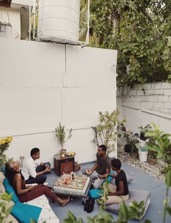 The city’s public water can be unreliable, so he has a large drum that stores his supply for dry days. The drum is secured by three reinforced concrete columns hidden from view. His deck is plywood and elevated just above the ground by posts underneath. The pillows also come from Saintil and the table is an IKEA frame on casters that Azor installed.