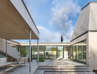 Supported by steel columns, it shades a portion of the courtyard, outfitted with Vintage lounge chairs by Tribù.