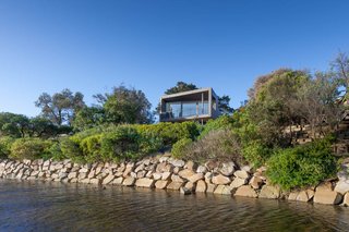 A small home in Australia is elevated to provide protection against potential flooding from the riverbank.