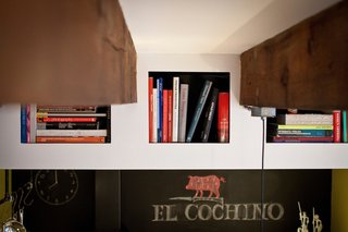 The architects carved these bookshelves into the drywall above the kitchen.