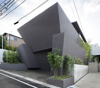 8 Distinct Ways of Living in Japan - Photo 4 of 8 - Concrete planters frame the facade—a union of monolithic slabs that offers privacy and compositional integrity to the building. The exterior is a plaster finish over insulation and concrete.