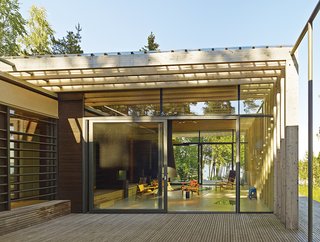 Light floods into the sparsely furnished living area thanks to the oversize glass doors.