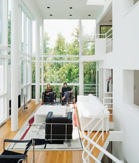 Richard Meier's 1973 Douglas House Receives Historic Designation - Photo 4 of 4 - The current homeowners, Michael McCarthy and Marcia Myers, pictured at home in the Douglas Residence, spent years rehabilitating the structure. The double-height living room features a custom sofa and low table of Meier’s design, and an Edward Fields rug based on a sketch Le Corbusier created in 1956 for a Tokyo theater.