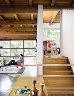 The exposed wooden rafters and grid of windows in the living room are original to the house.