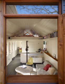 Tiny 1920s Garage Transformed Into a Charming Studio - Photo 3 of 8 - Light cascades into the living room through a row of six insulated timber windows on the south wall. The north wall flares out to create what Schaer calls a sunset scoop. "It grabs the late afternoon and evening sun and brings it deep into the space," he explains.
