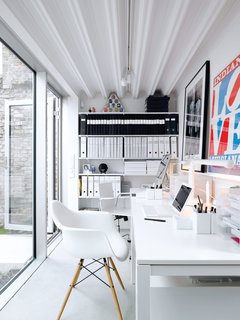 The office, which is a single-level separate unit, boasts Ikea desks and a signed work by Gilbert and George (friends of the couple).
