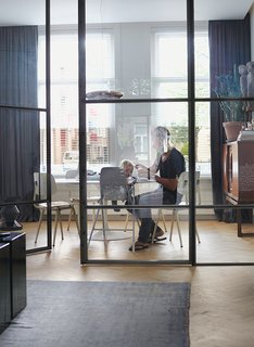 Nederhof and his son Scott sit at a Tulip table by Eero Saarinen for Knoll in the flexible office area. The chairs are by Friso Kramer for Ahrend, and the Corona pendant light is from Established & Sons.