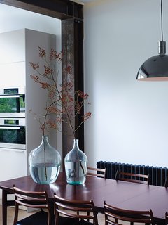 A vintage Danish dining table in palisander wood by Arne Vodder is paired with chairs by Niels Møller.