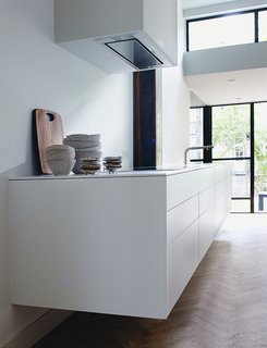 The sleek, white kitchen is by Bulthaup.