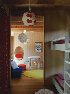 The couple’s ten-year-old twins have connecting rooms next to a play space furnished with Aalto stools, a table from Artek, and a Nanna Ditzel rattan hanging chair purchased at Interstudio.