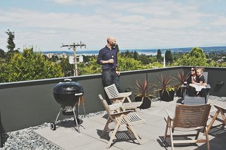 Rex folding rocker chairs from Design Within Reach are paired with black galvanized-steel planters from Ikea on the building’s roof deck.