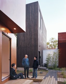 Schenk, Kim, and Kaewlai chat outside of X-Small, standing on the reclaimed wood used to build the boardwalks that connect all four properties. The translucent corridor connecting Small and Medium illuminates the common space throughout the evening.