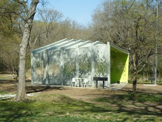 A shallow gabled roof slopes gently from a front corner to the pavilion's rear. Photo by Architexas.
