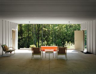 Industrial Revolution - Photo 7 of 7 - Cook and Compa turned a carport into a breezeway, adding patio furniture and an orange bench to give the space a dash of color. Along with the patio, it adds 1,300 square feet of usable space during the warmer months.